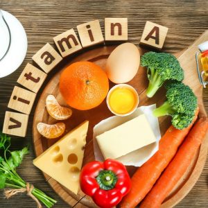 Verschiedene Lebensmittel die Vitamin A ethalten auf einem Holzbrett