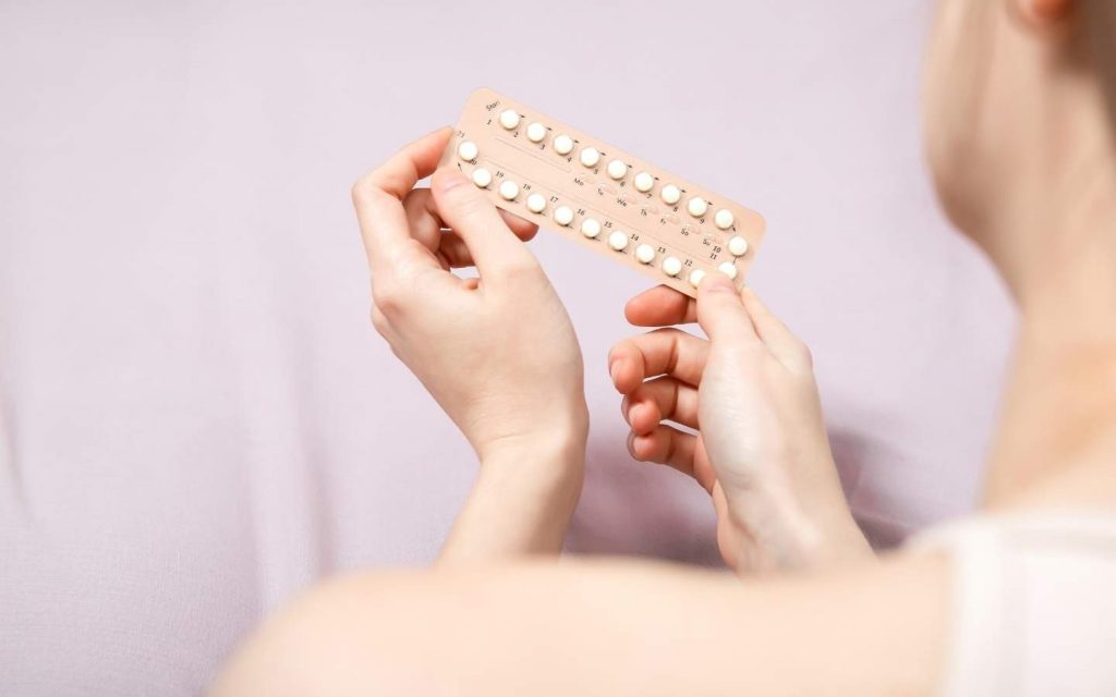 Frauenhände halten eine Pillen Packung